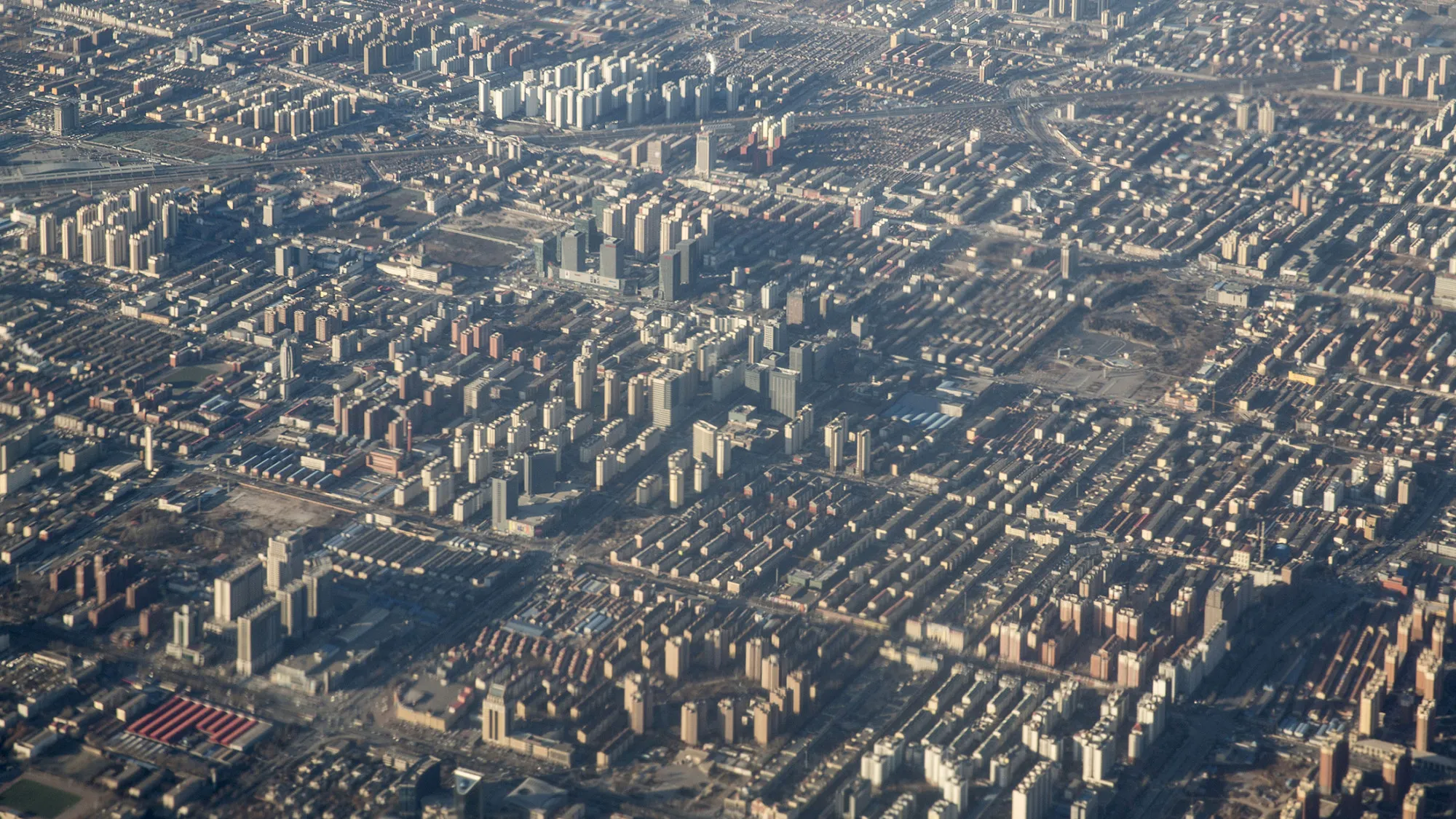Buildings stand in this aerial photograph taken in Beijing, China, on Monday, Jan. 18, 2016. China's economy slowed in December, capping the weakest quarter of growth since the 2009 global recession, as the Communist leadership struggles to manage a transition to consumer-led expansion.
