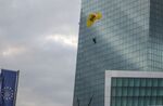 A Greenpeace activist lands with a paraglider on the roof of the ECB.