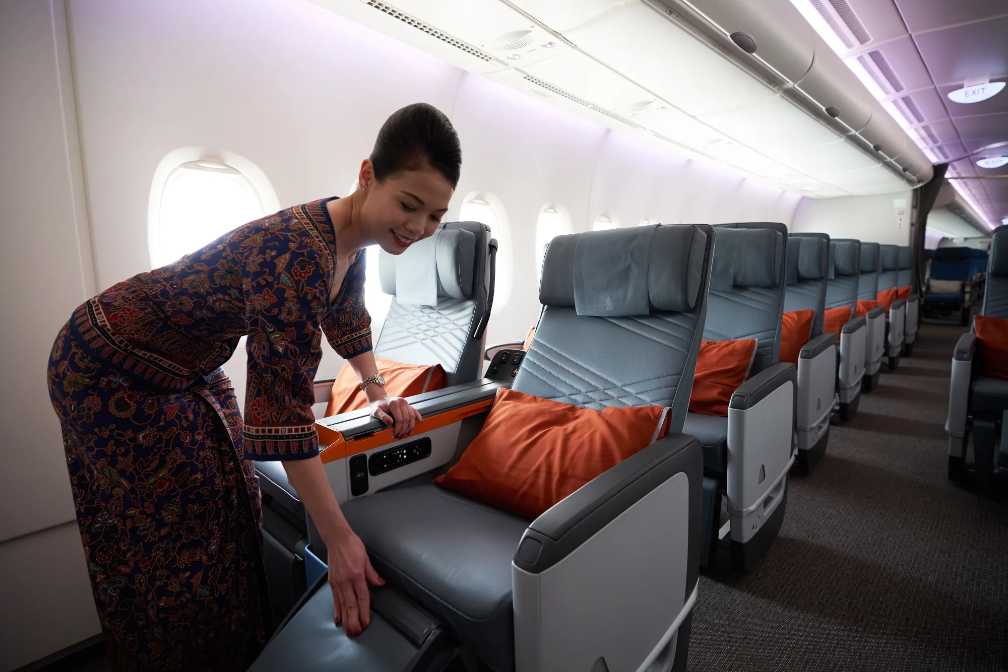 A flight attendant arranges a premium class seat of a Singapore Airlines aircraft.