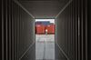 A worker walks past newly finished shipping containers sitting in a stockyard at the SingamasContainer Holdings Ltd. factory in Qidong, China, on Thursday, June 22, 2017.