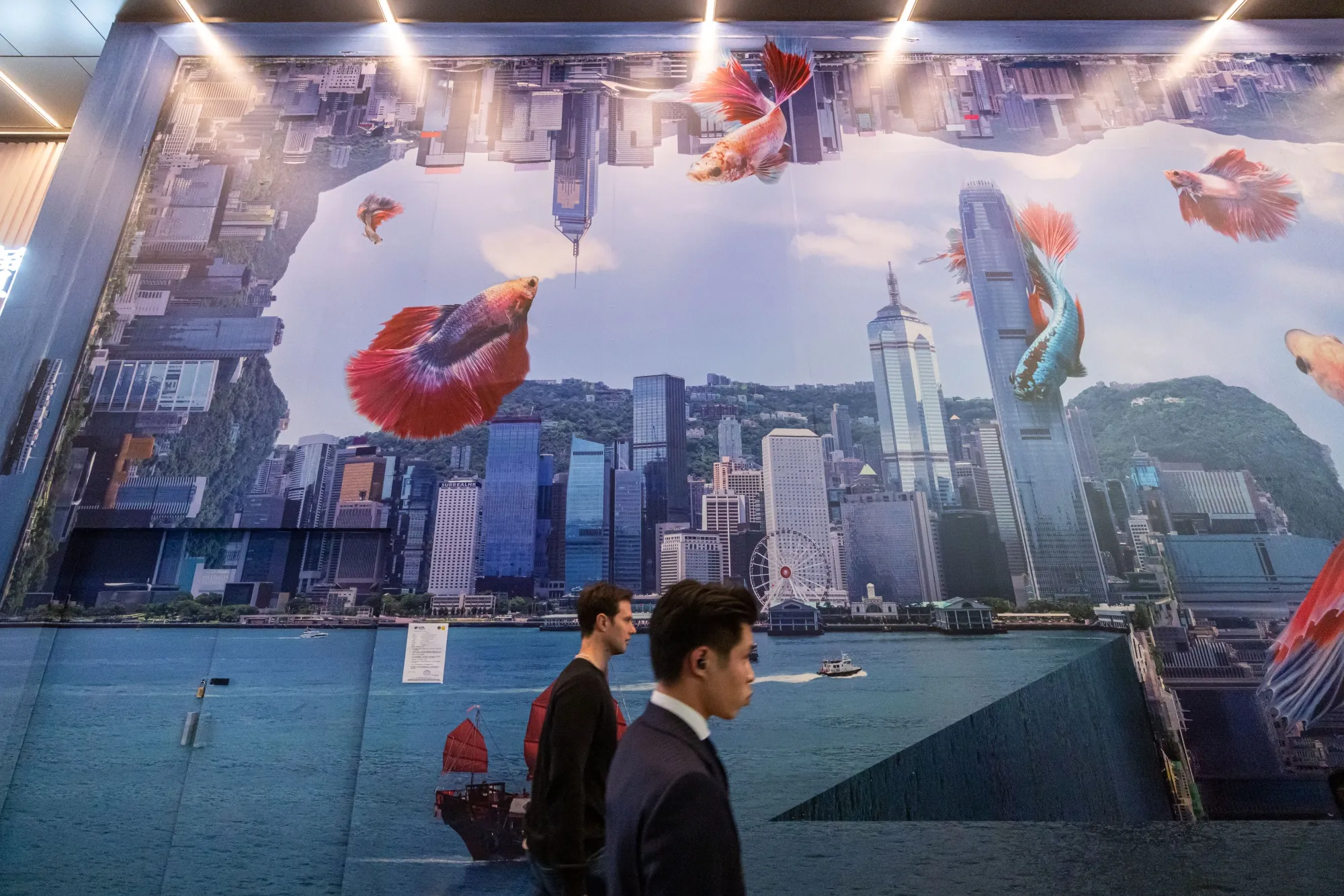 Pedestrians pass a backdrop of Hong Kong’s skyline in the city’s central district.