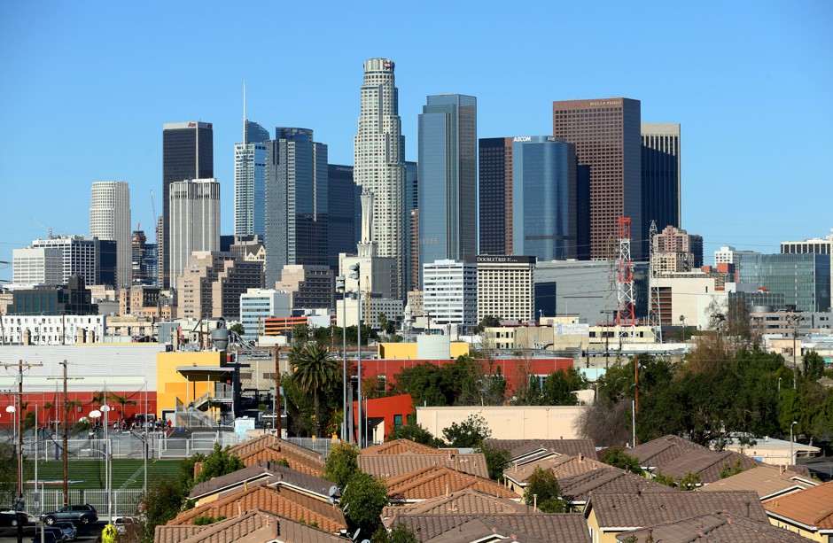 The Los Angeles skyline looms above single-family homes. 