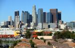 The Los Angeles skyline looms above single-family homes. 