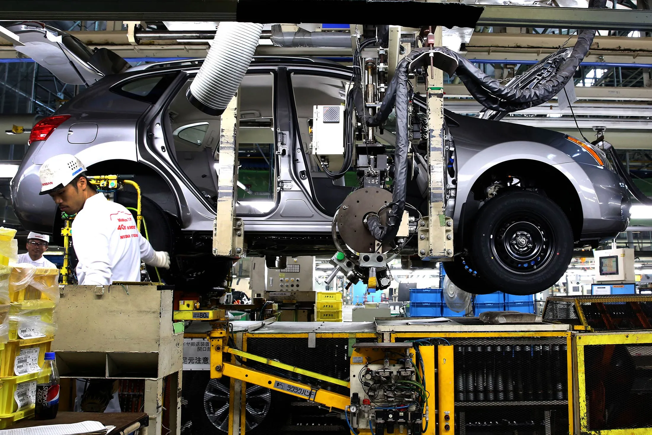 An employee assembles a Nissan Motor Co. SUV on the production line of the company's Kyushu plant in Kanda Town, Fukuoka Prefecture, Japan, on July 9, 2015.
