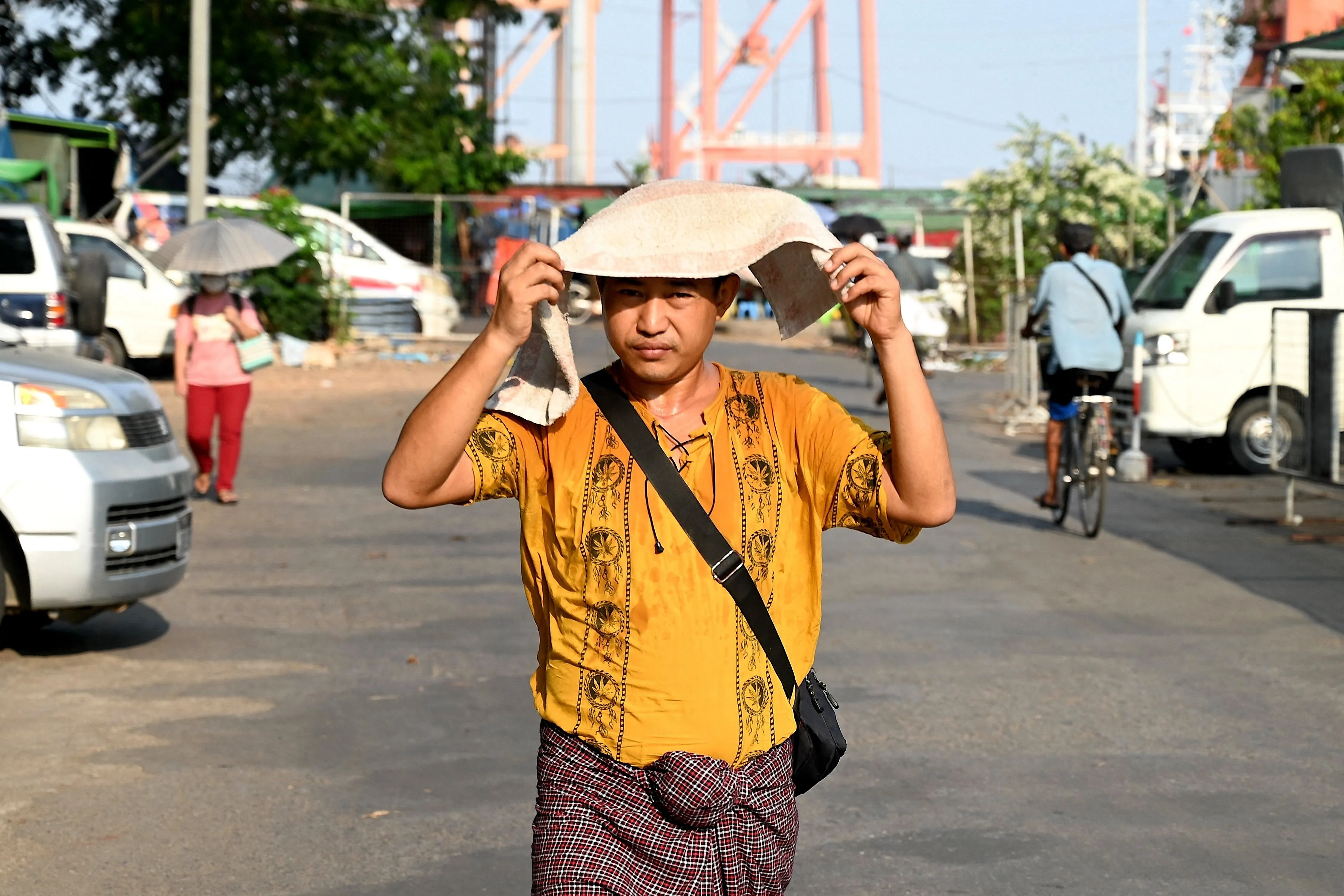 A man covers his head with a towel to shelter from the sun during heatwave conditions in Yangon on May 8.