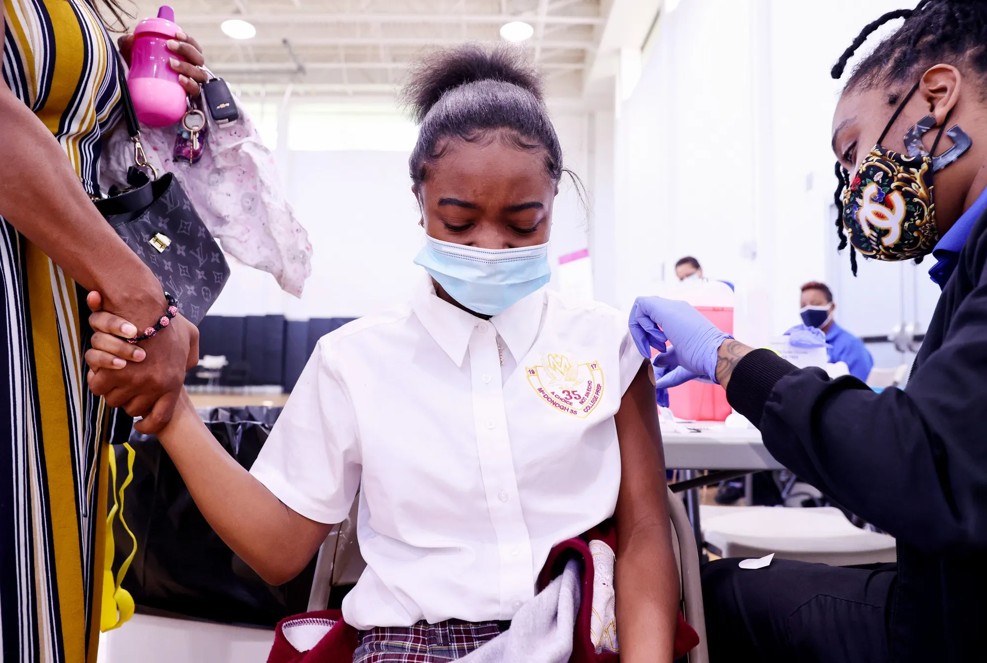 Amya Feltus,&nbsp;13, holds her mother’s hand&nbsp;after receiving a COVID-19 vaccination dose at a clinic&nbsp;in New Orleans.