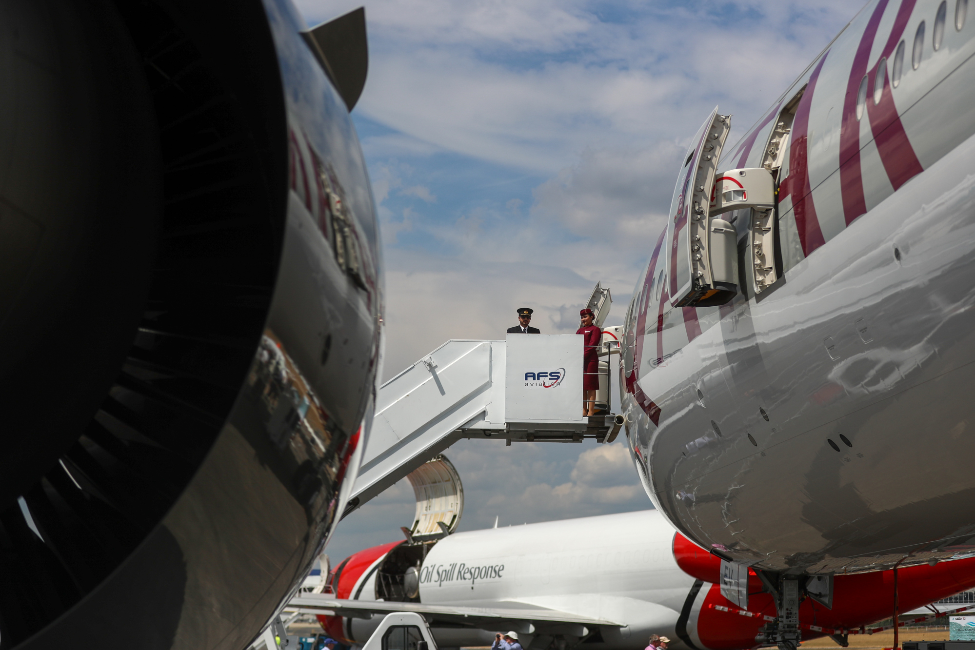 Aircrew stand at the top of steps at the entrance to a Qatar Airways&nbsp;Airbus A350 passenger aircraft at the Farnborough International Airshow in Farnborough, U.K., in 2018.&nbsp;