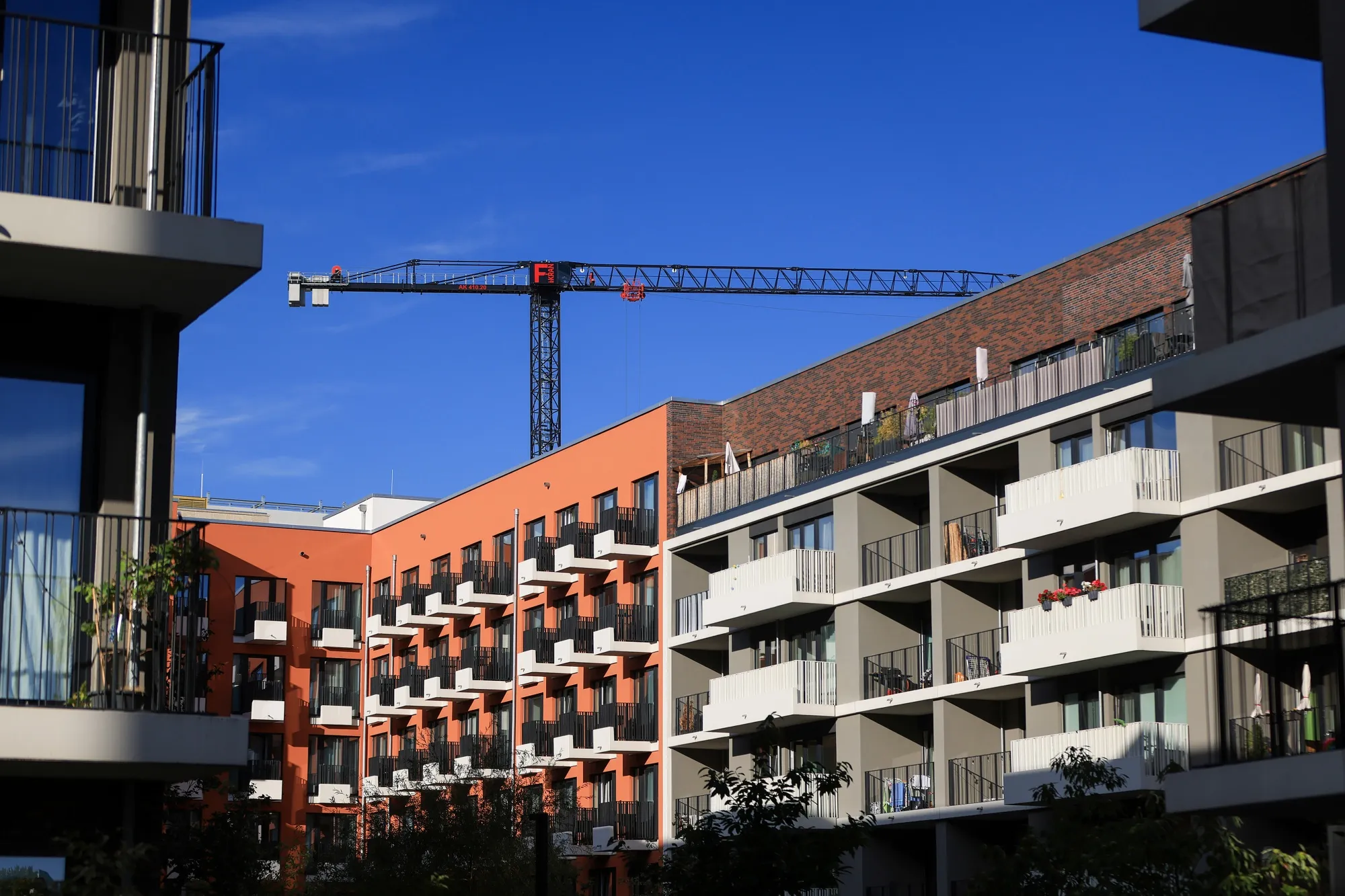 A construction crane behind residential apartments in Berlin.