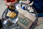 Customers eat lunch outside a Whole Foods Market Inc.