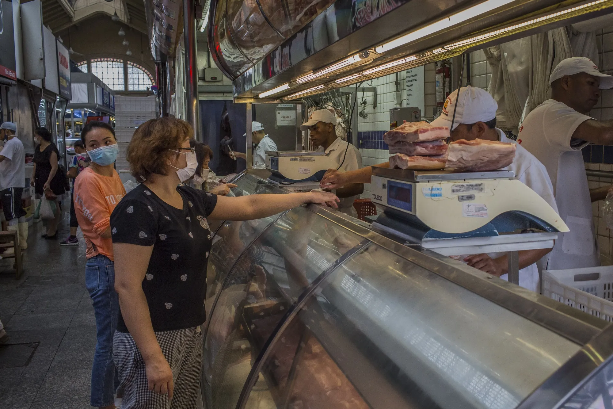 Shoppers wearing protective masks order meat inside the Municipal Market in Sao Paulo, Brazil, on&nbsp;March 19.