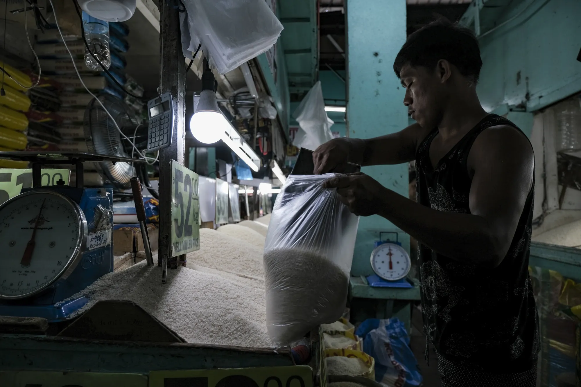 A vendor packs a bag of rice at a market stall in Quezon City, Metro Manila.