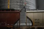 A worker walks across the top of a railroad grain hopper car at a. transloading facility in Edinburgh, Indiana.
