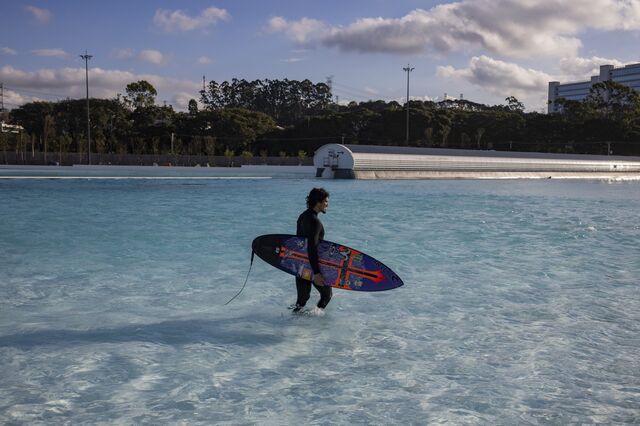 World surfing champion Gabriel Medina, carrying a board, walks in the surf pool at Beyond The Club. 