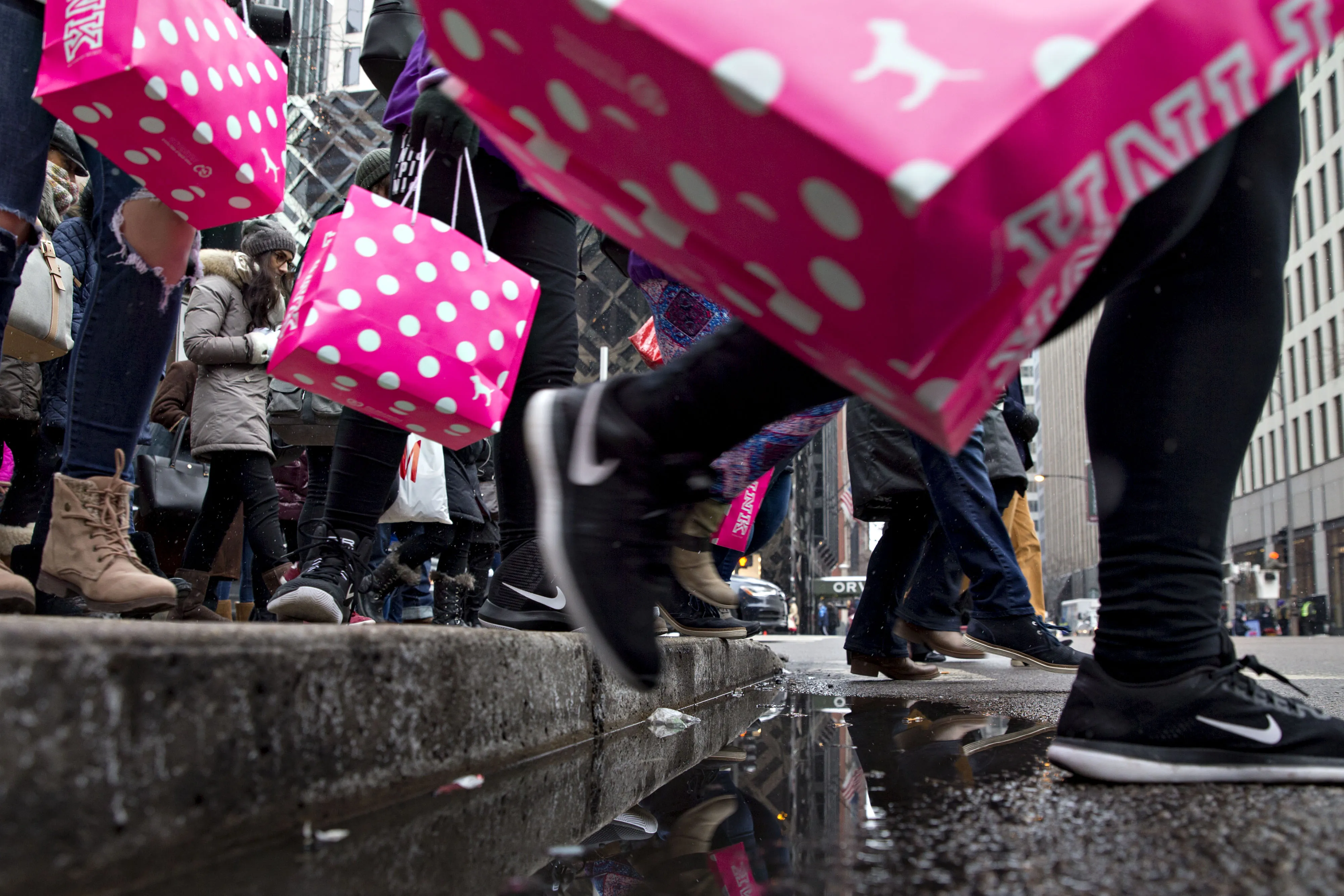 Shoppers carry L Brands Inc.&nbsp;Pink bags while walking through the Magnificent Mile commercial district in Chicago, Illinois, U.S.