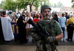 An armed white supremacist stands in front of a crowd of counter protesters in Charlottesville on August 12. 