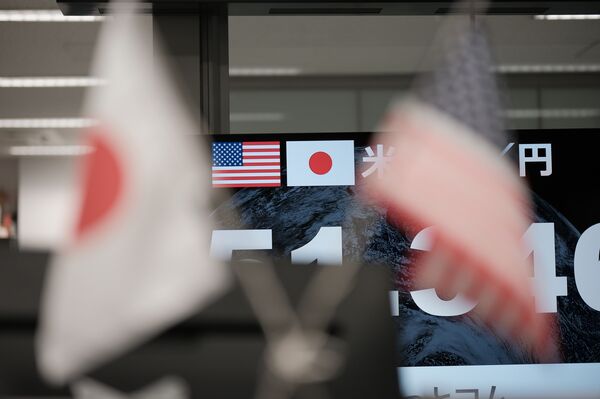 The US and Japanese flags on a screen in the trading room at foreign exchange brokerage Gaitame.Com Co. in Tokyo, Japan. 