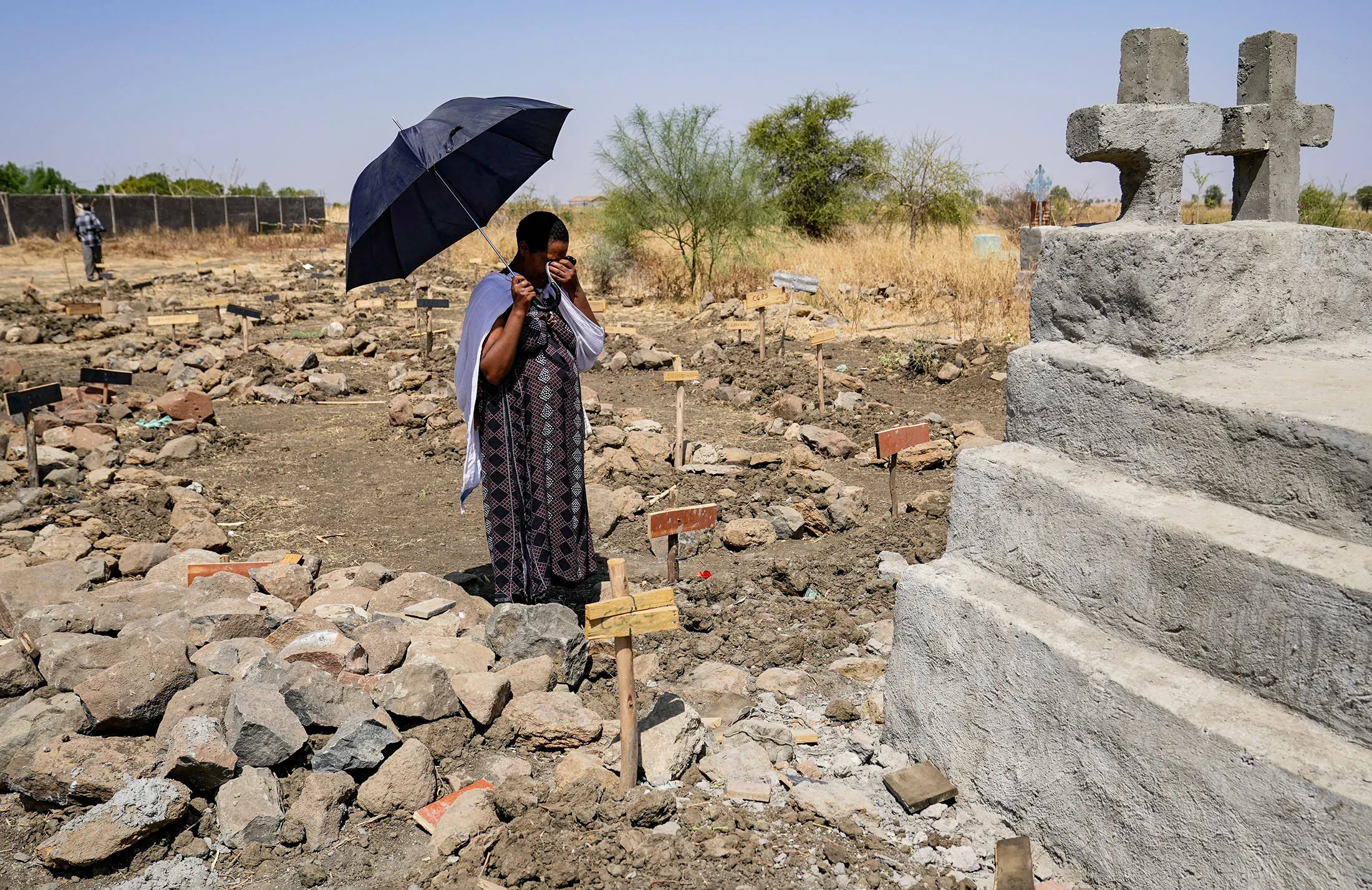 A mourner weeps in front of a tomb among the mass graves following a series of attacks by the Tigray People’s Liberation Front, in Mai Kadra, Ethiopia.