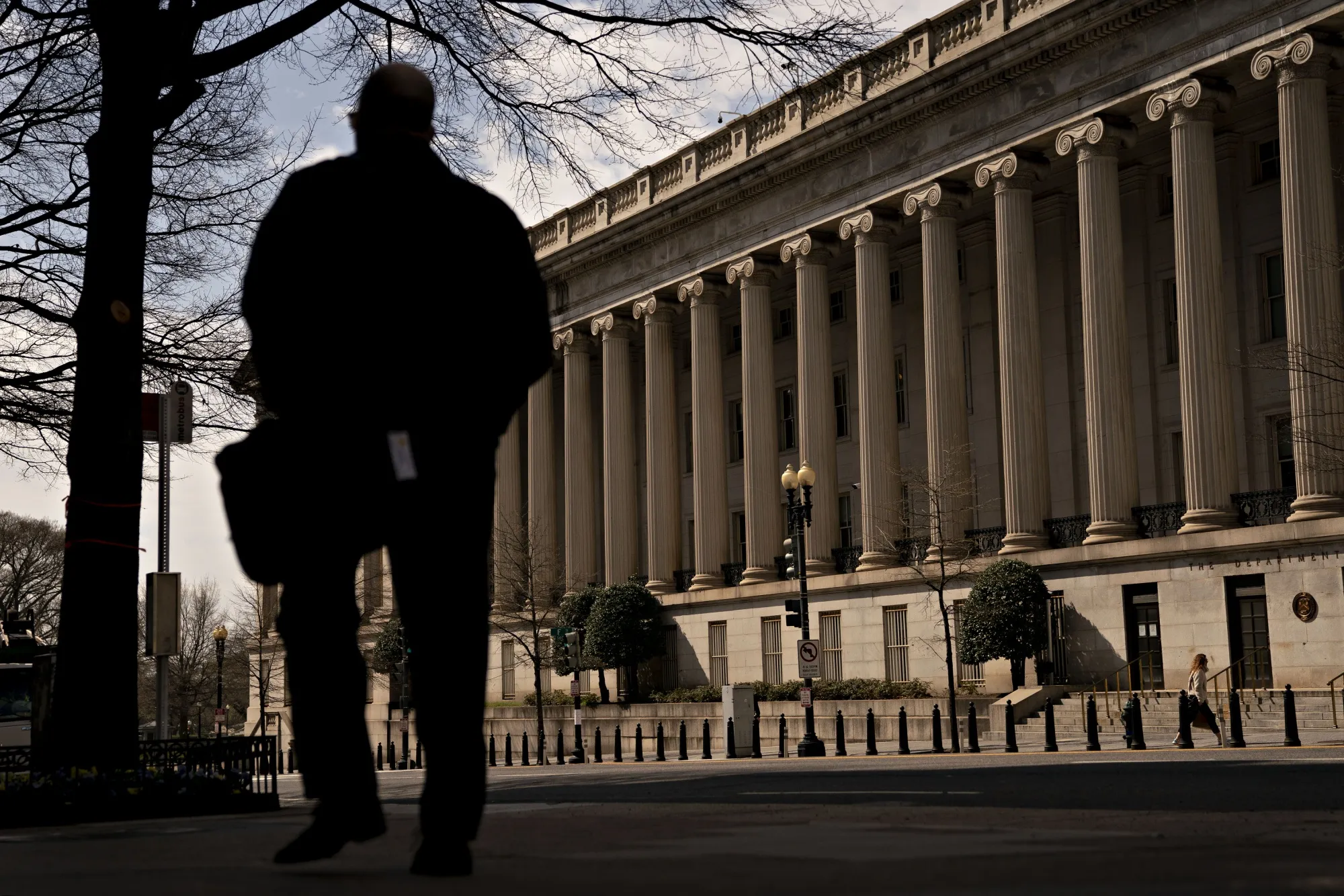 A pedestrian walks near the U.S. Treasury building in Washington, D.C.,&nbsp;on&nbsp;March 17.&nbsp;