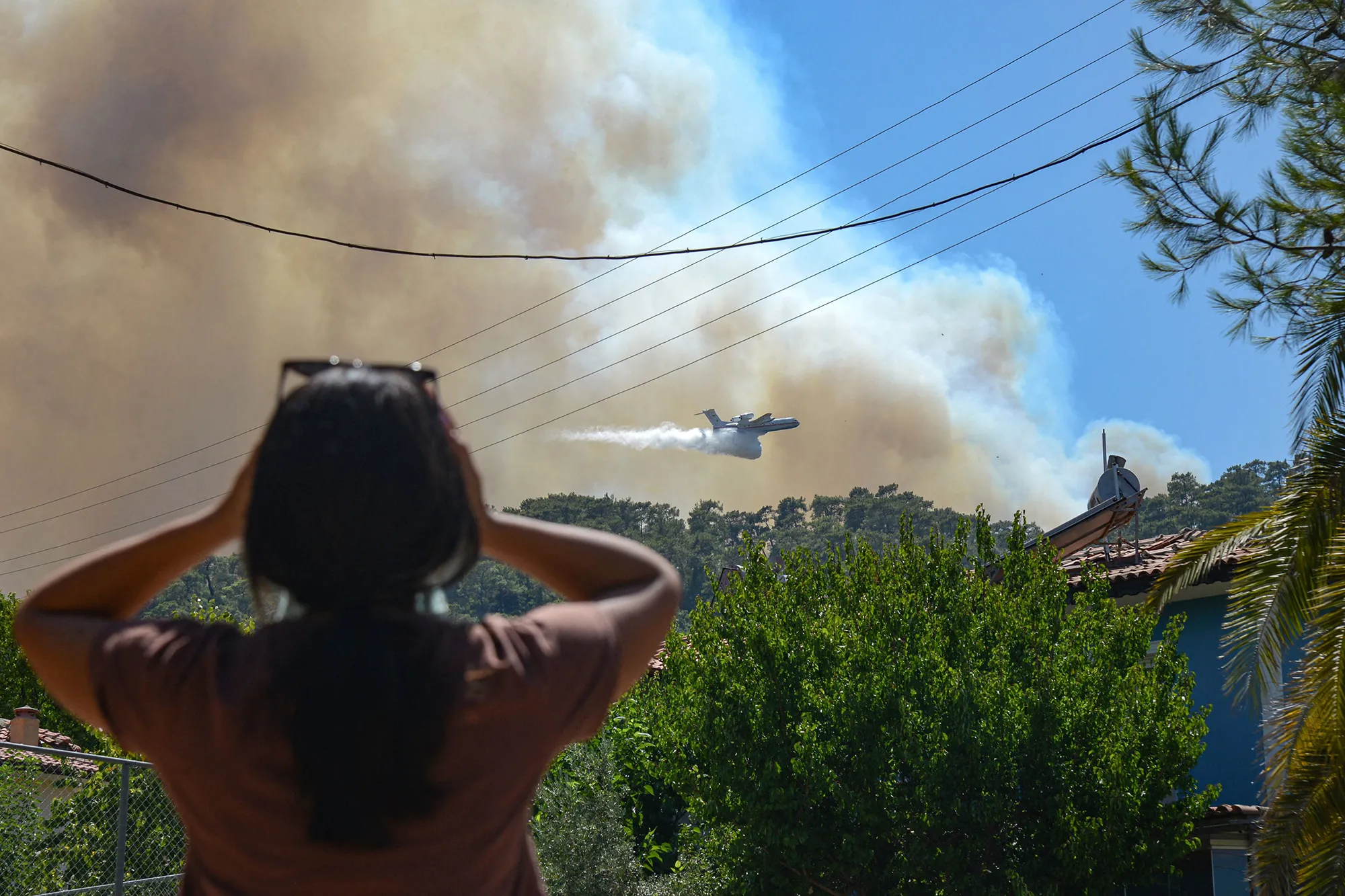 A firefighting aircraft drops water to extinguish a massive forest fire which engulfed a Mediterranean resort region, on Turkey’s southern coast, near Marmaris, on July 30.