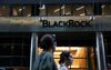Pedestrians walk past BlackRock Inc. headquarters in New York.