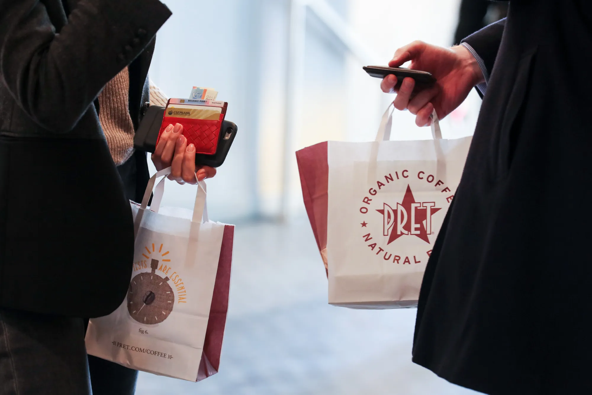 Customers hold bags inside a branch of food retailer Pret a Manger Ltd. in London, U.K., on Monday, March 27, 2017.