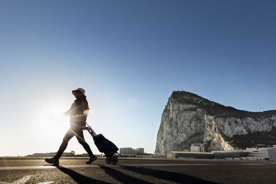 A woman wheels her suitcase along the Spanish border with the British Overseas Territory of Gibraltar