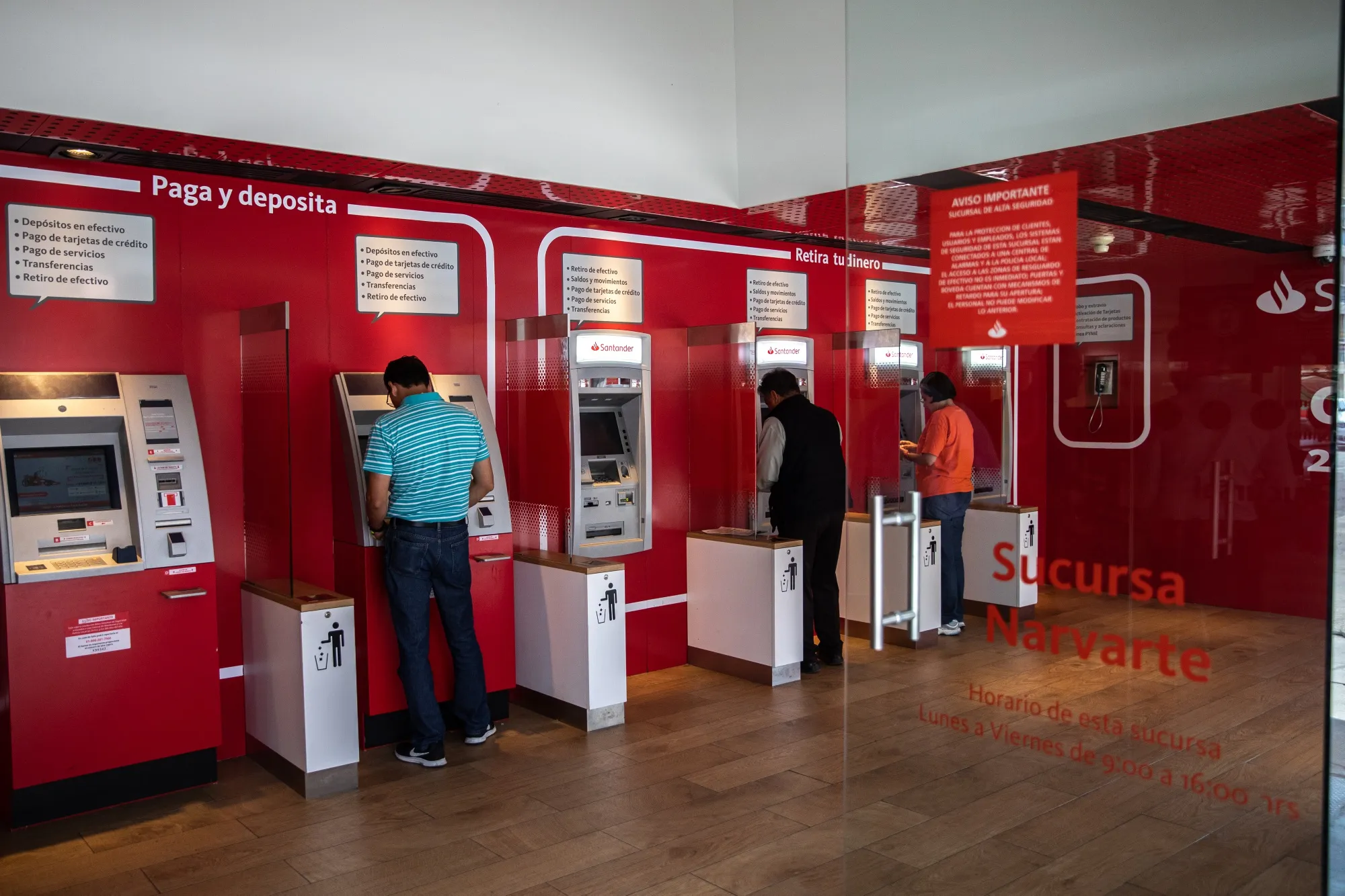 Customers use automatic teller machines (ATM) at a Grupo Financiero Santander Mexico SAB bank branch in Mexico City, Mexico, on Friday, Nov. 9, 2018. Mexico's incoming president moved to quell a rebellion among investors worried about state interference in the economy, assuring them he had no plans to change banking laws. Stocks and the currency reversed the bulk of their losses.