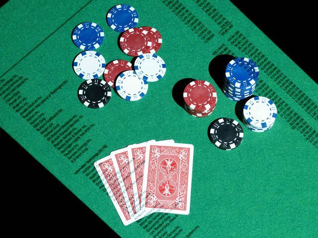 Photograph of playing cards and poker chips laid out on a table.