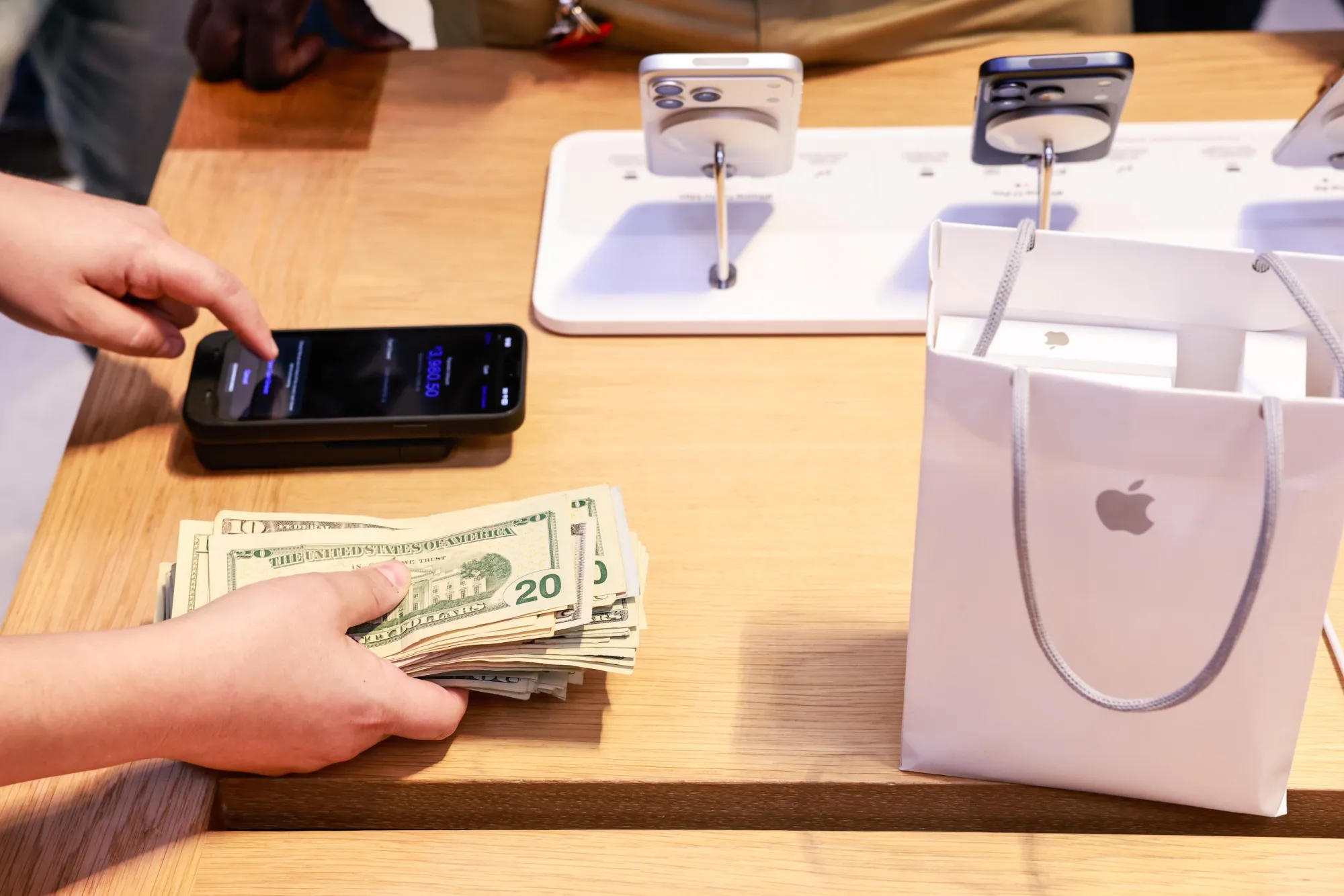 A worker counts dollar bills during the first day of in-store sales of Apple’s latest products at its&nbsp;Fifth Avenue store in New York.