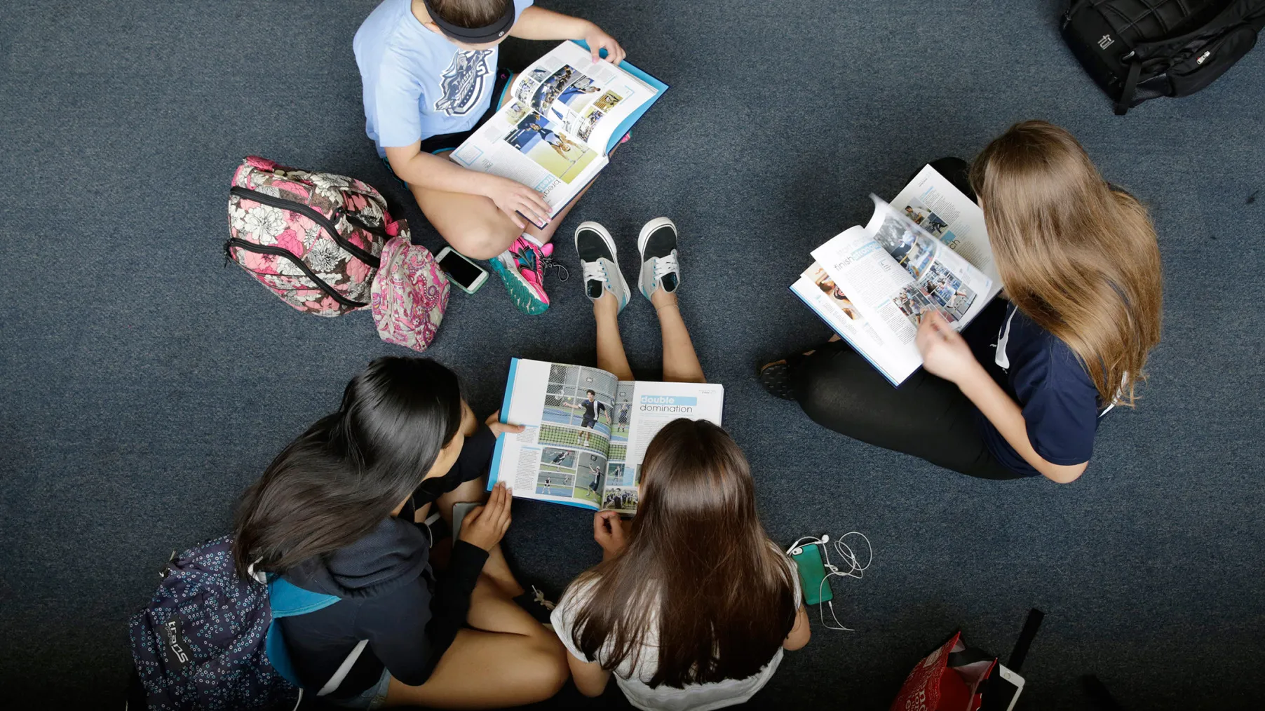 Students sit with their new yearbooks.
