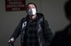 A traveler arriving on a flight from Beijing wears a disposable face mask at San Francisco International Airport in San Francisco, California, U.S.