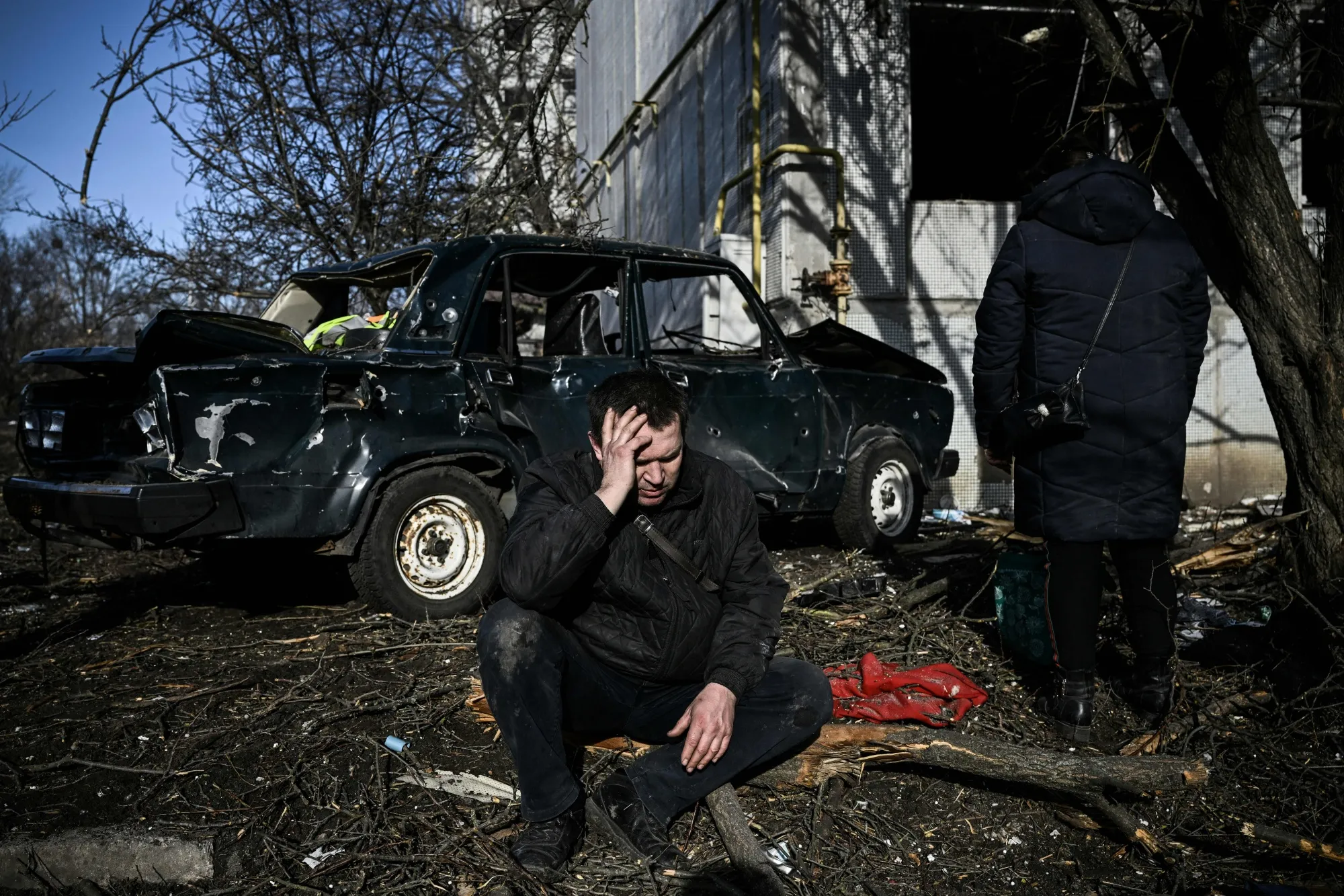 A man sits outside his destroyed building after bombings on the eastern Ukraine town of Chuguiv on Feb. 24, 2022.
