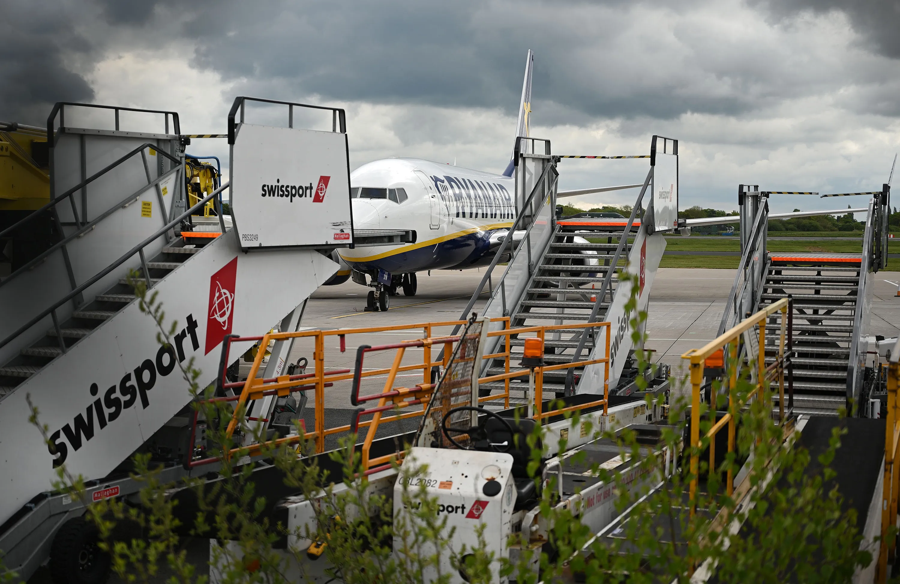 A grounded aircraft, operated by Ryanair, is pictured beyond unused Swissport stairs, at Manchester Airport, on May 1.