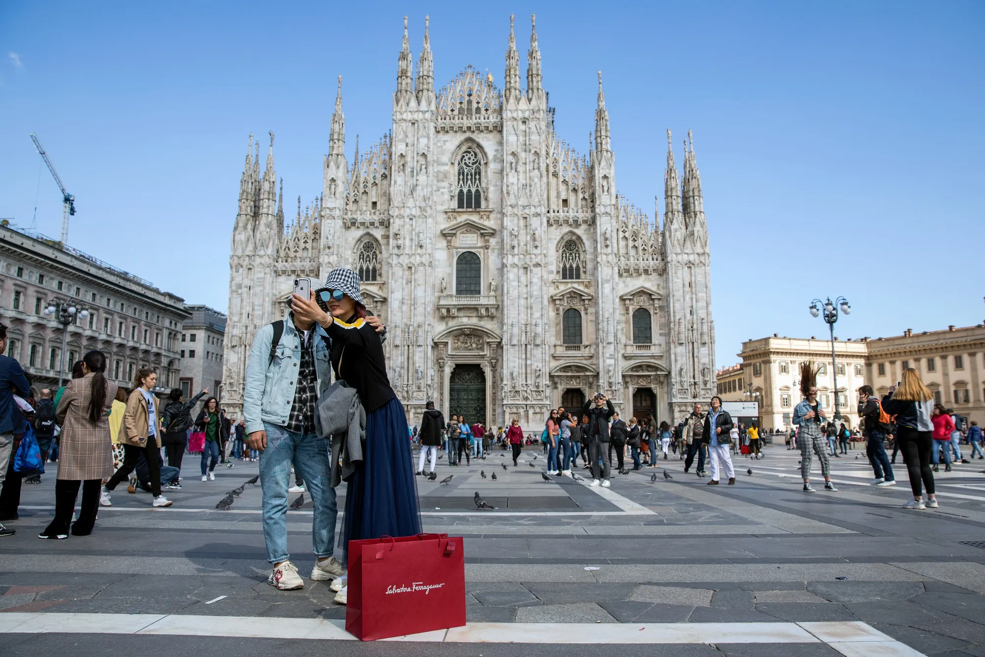 Pedestrians take&nbsp;photographs in front of the Duomo cathedral in Milan.