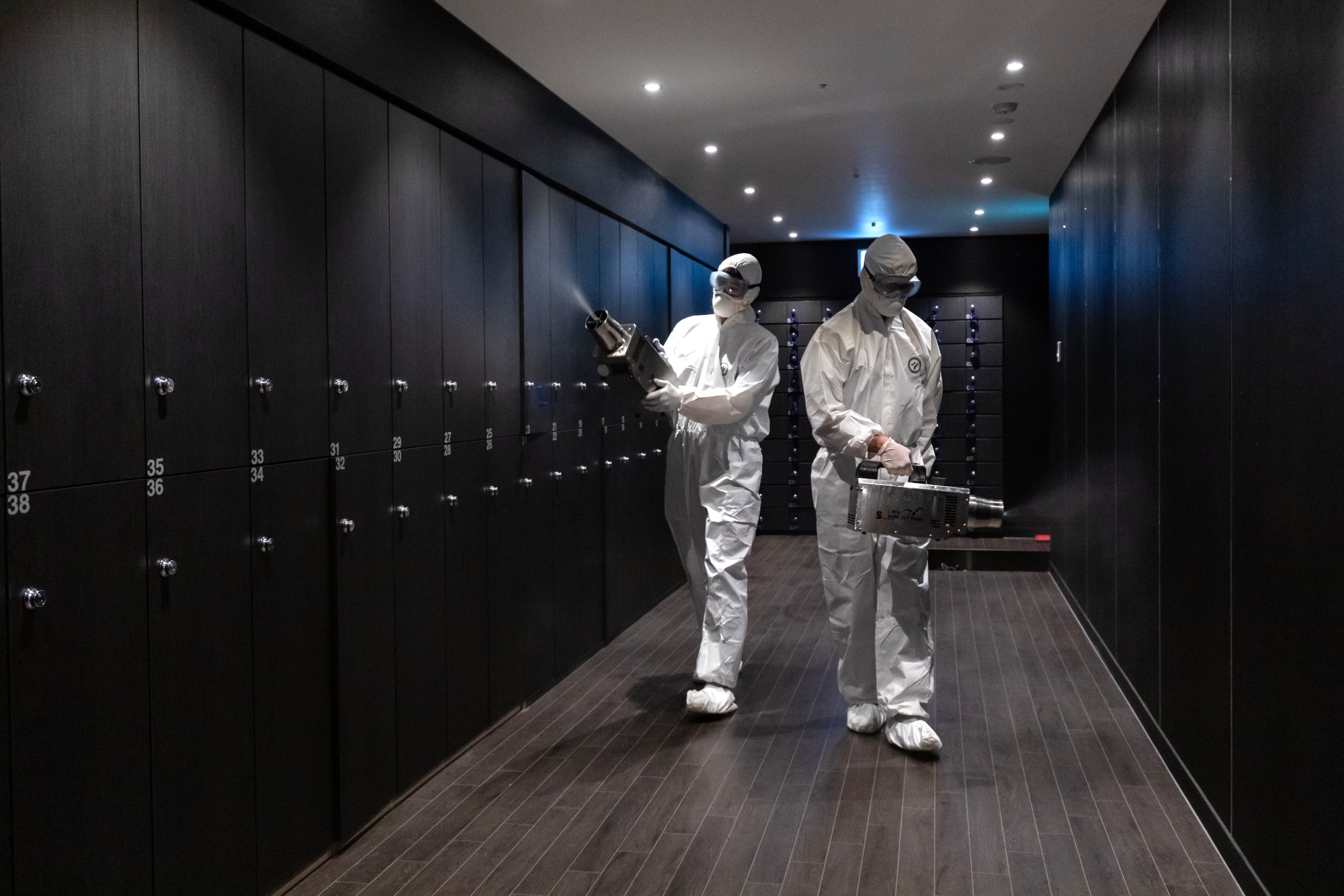 Workers spray&nbsp;disinfectant inside a fitness club in Seoul May 11.