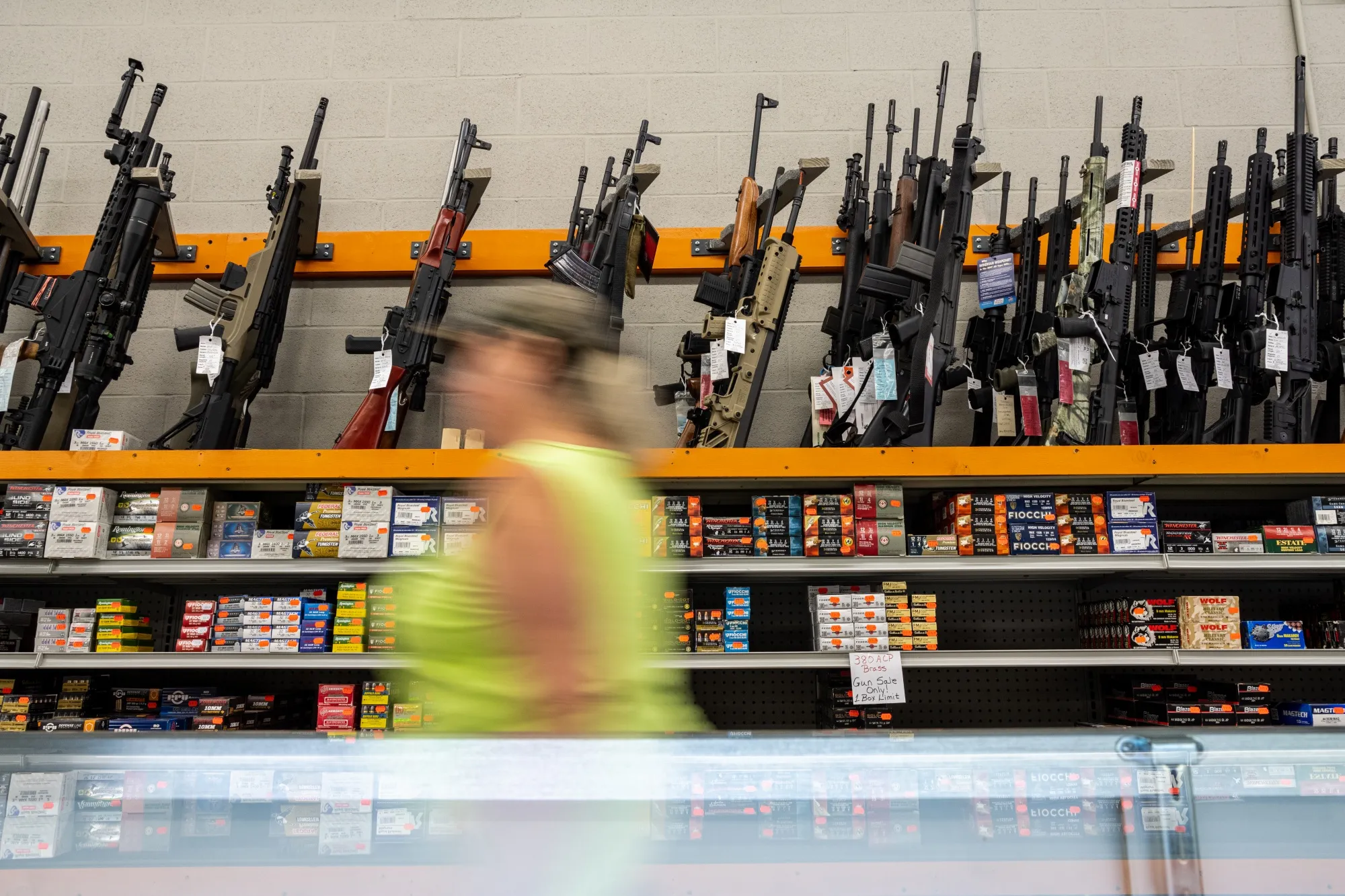 An employee passes rifles for sale at a store&nbsp;in West Point, Kentucky.