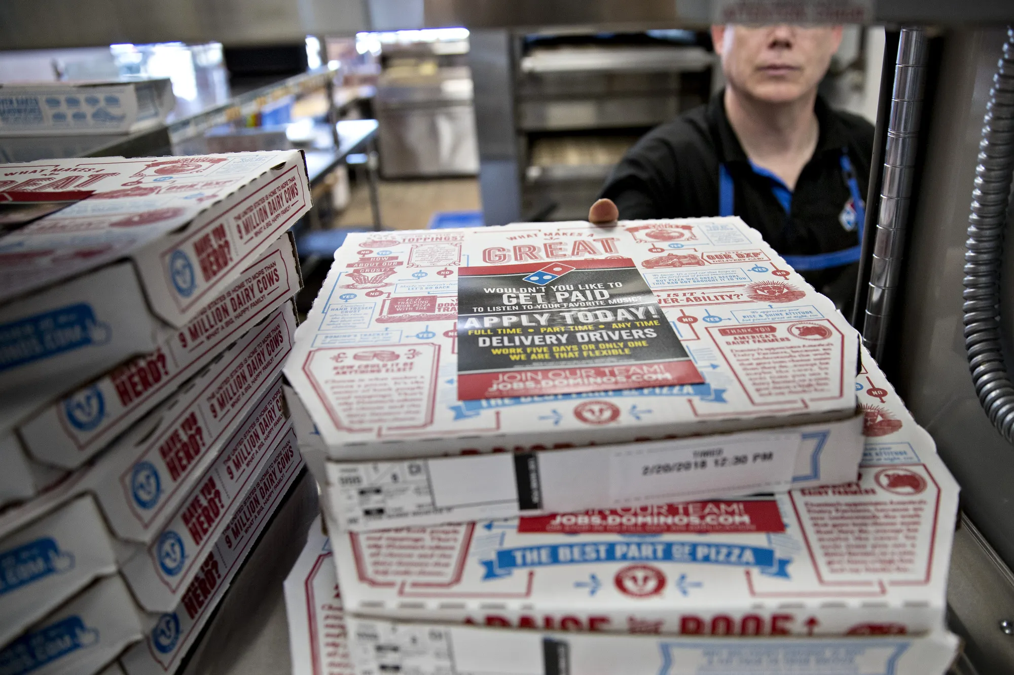An employee places a pizza box onto a shelf at a Domino's Pizza restaurant in Chantilly, Virginia.
