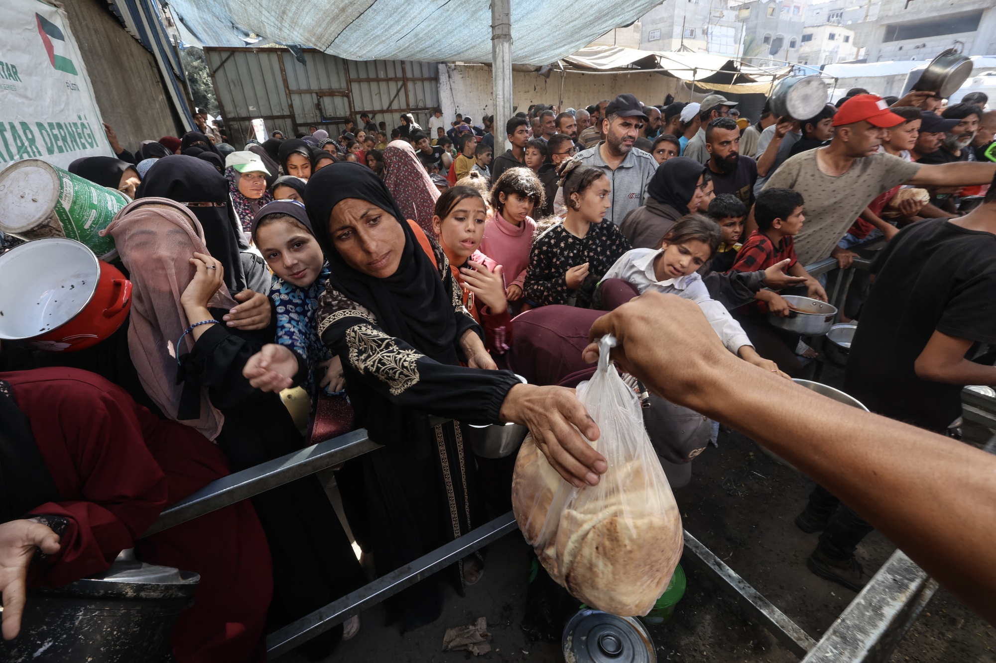 Palestinians receive food from a charity kitchen in Nuseirat refugee camp, central Gaza, on OCt. 15. Photographer: Eyad Baba&#x2F;AFP&#x2F;Getty Images