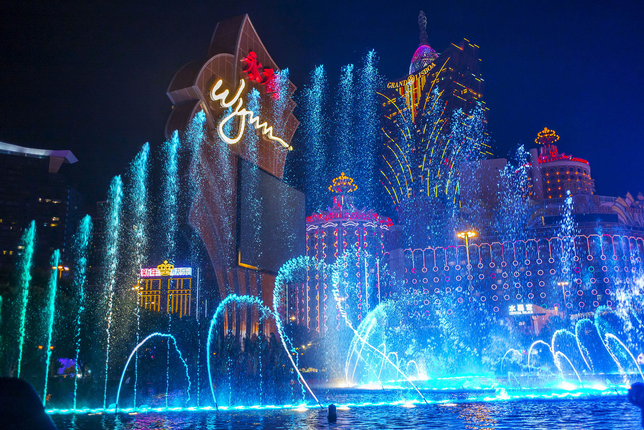 Water from a fountain sprays into the air in front of the Wynn Macau casino resort.
