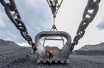A worker inspects a giant crane bucket at an open pit coal mine in Russia.