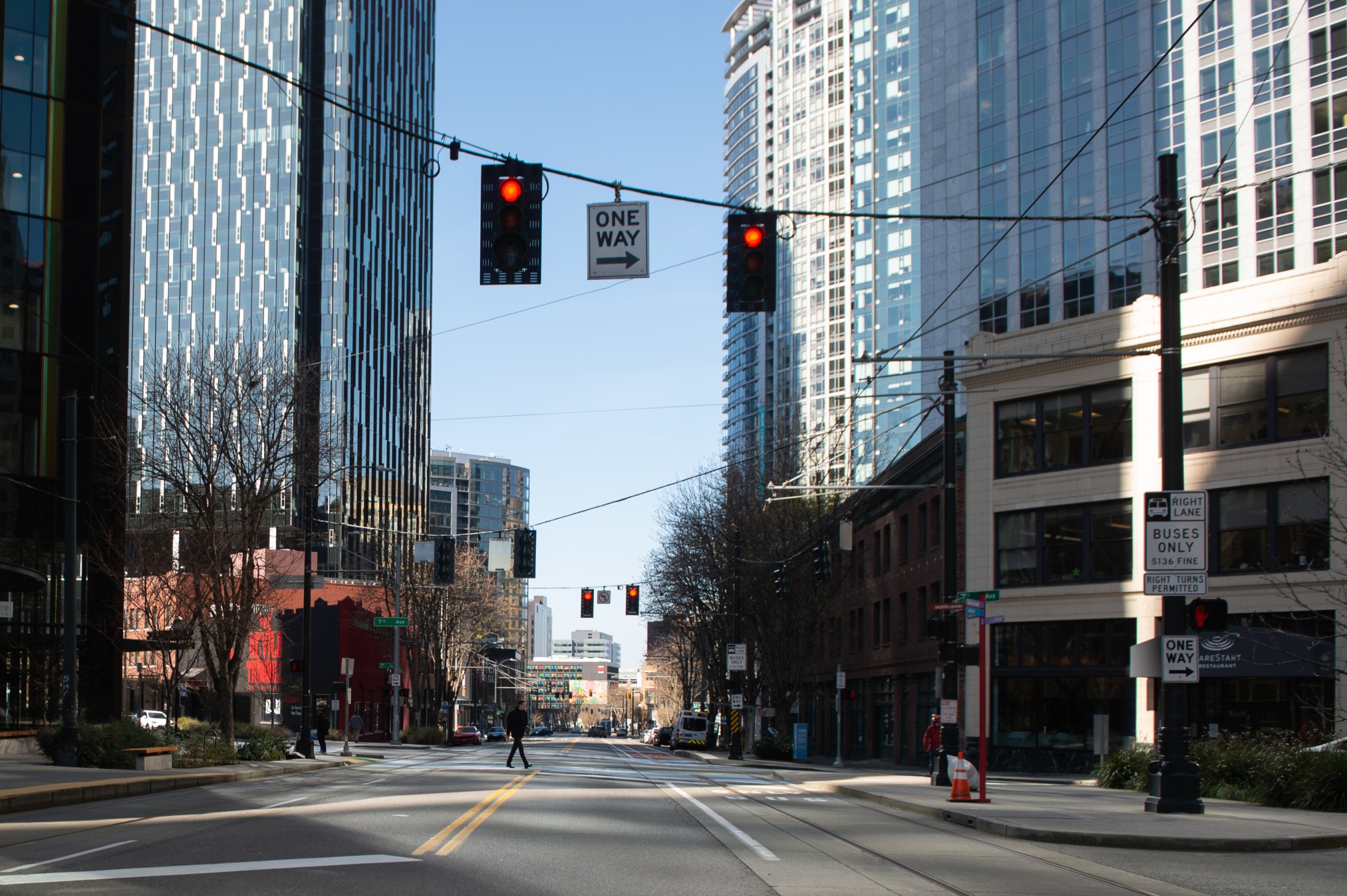 A pedestrian crosses a nearly empty road in Seattle.