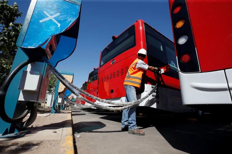 A man plugs in an electric bus manufactured by China's BYD, part of a new fleet of electric buses for public transit in Santiago, Chile.