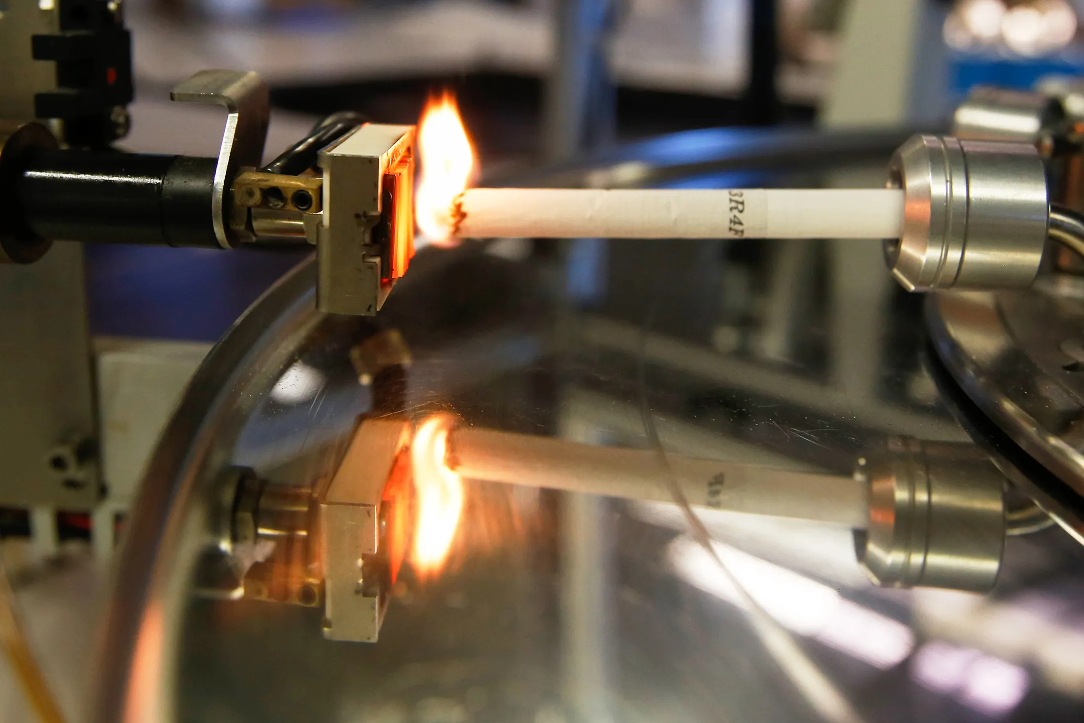 A cigarette is automatically lit in a smoking machine at the British American Tobacco Plc research and development laboratories in Southampton, UK.