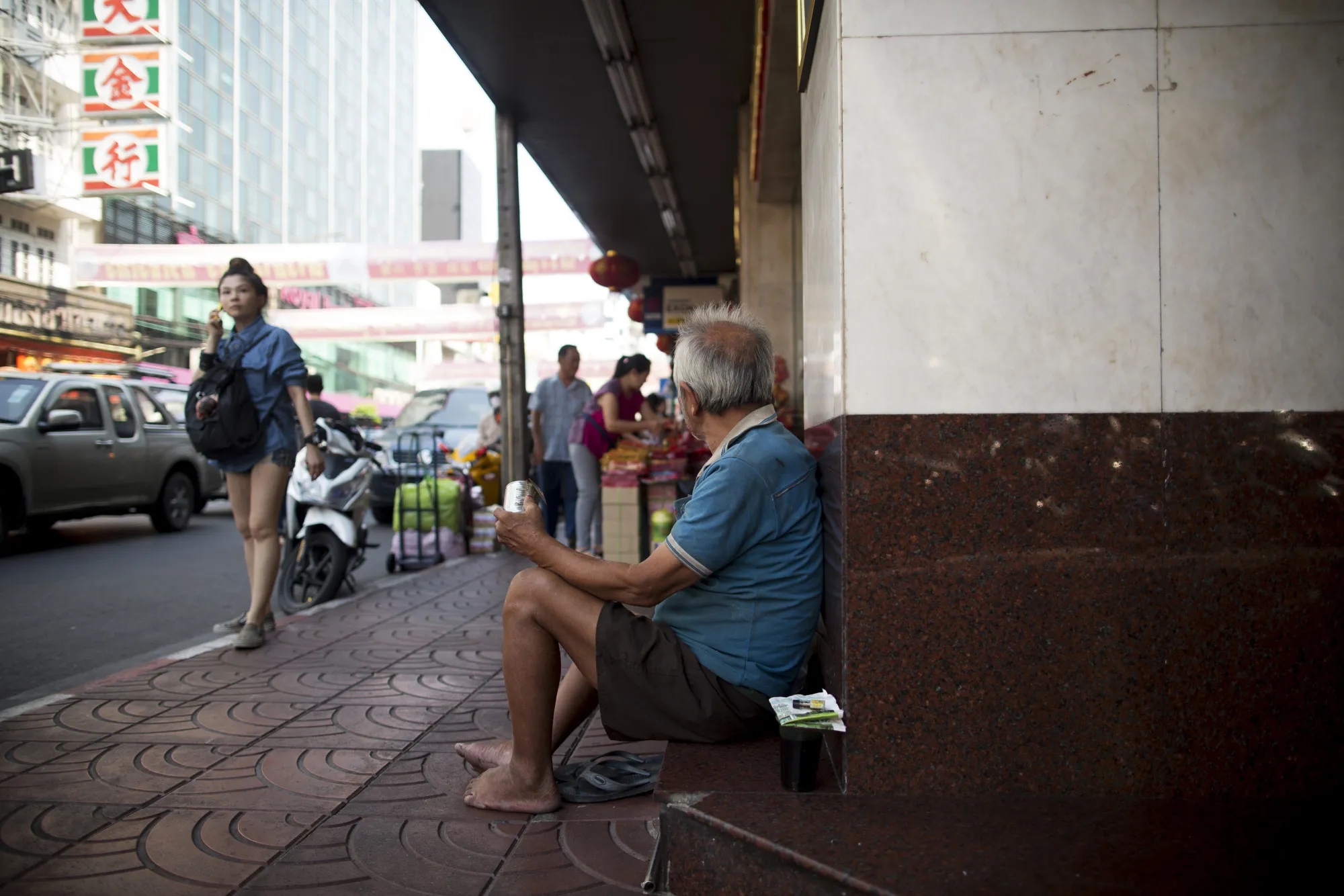 A man begs on a street in the Chinatown district of Bangkok.