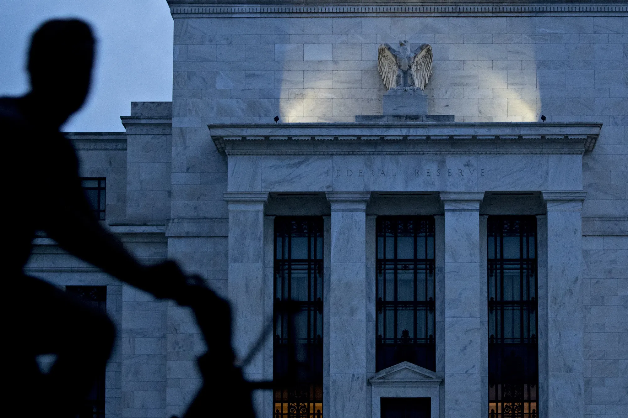 A bicyclist passes the Marriner S. Eccles Federal Reserve building.