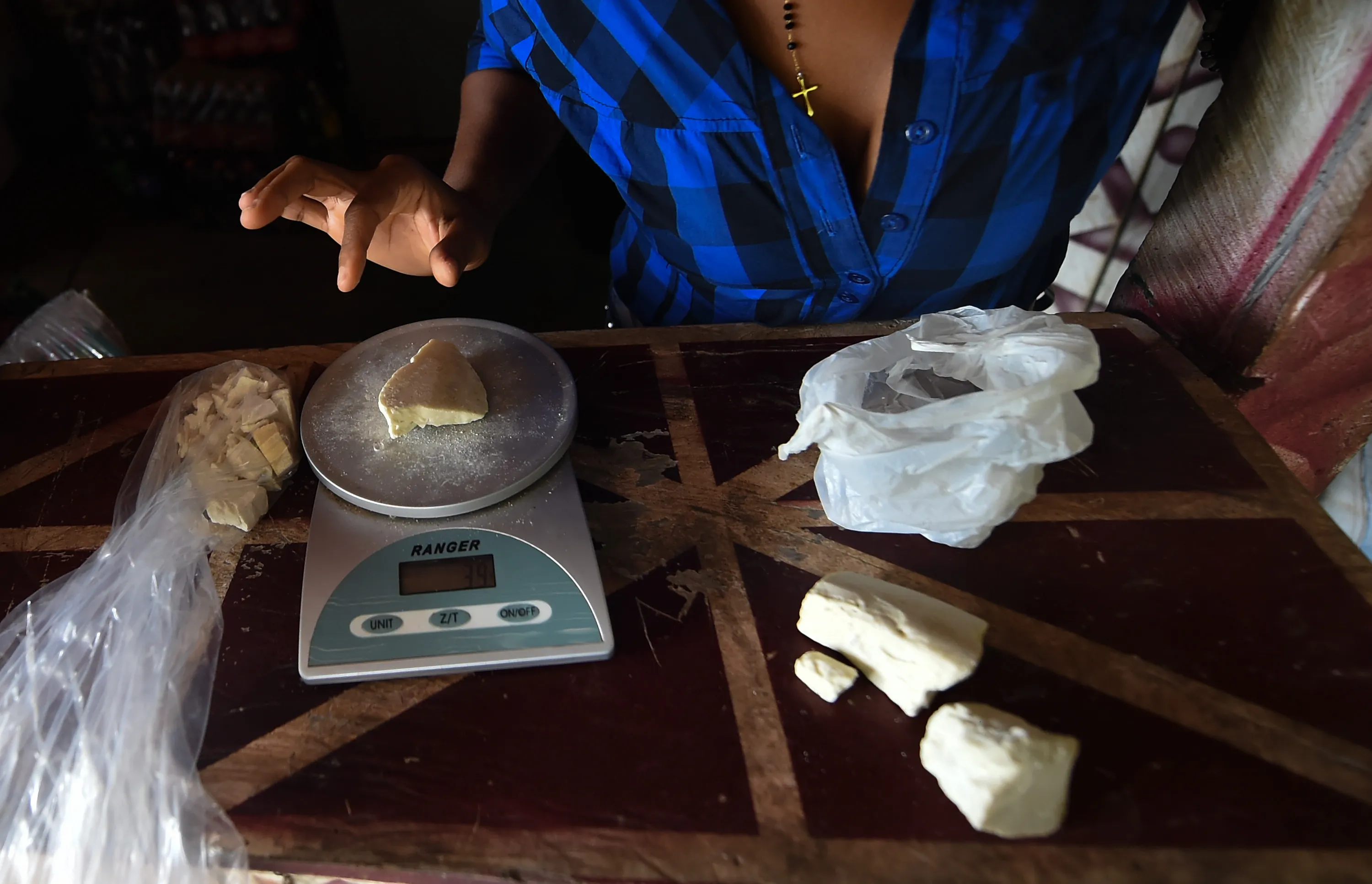 A grocer weighs cocaine base paste at a store in La Paz, Colombia.