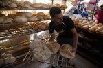 A worker arranges freshly baked bread for sale at the Al-Monira market in Cairo, June 1. 