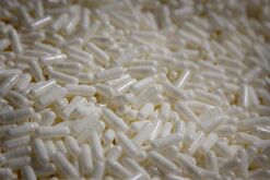 White capsules are sorted into a pile