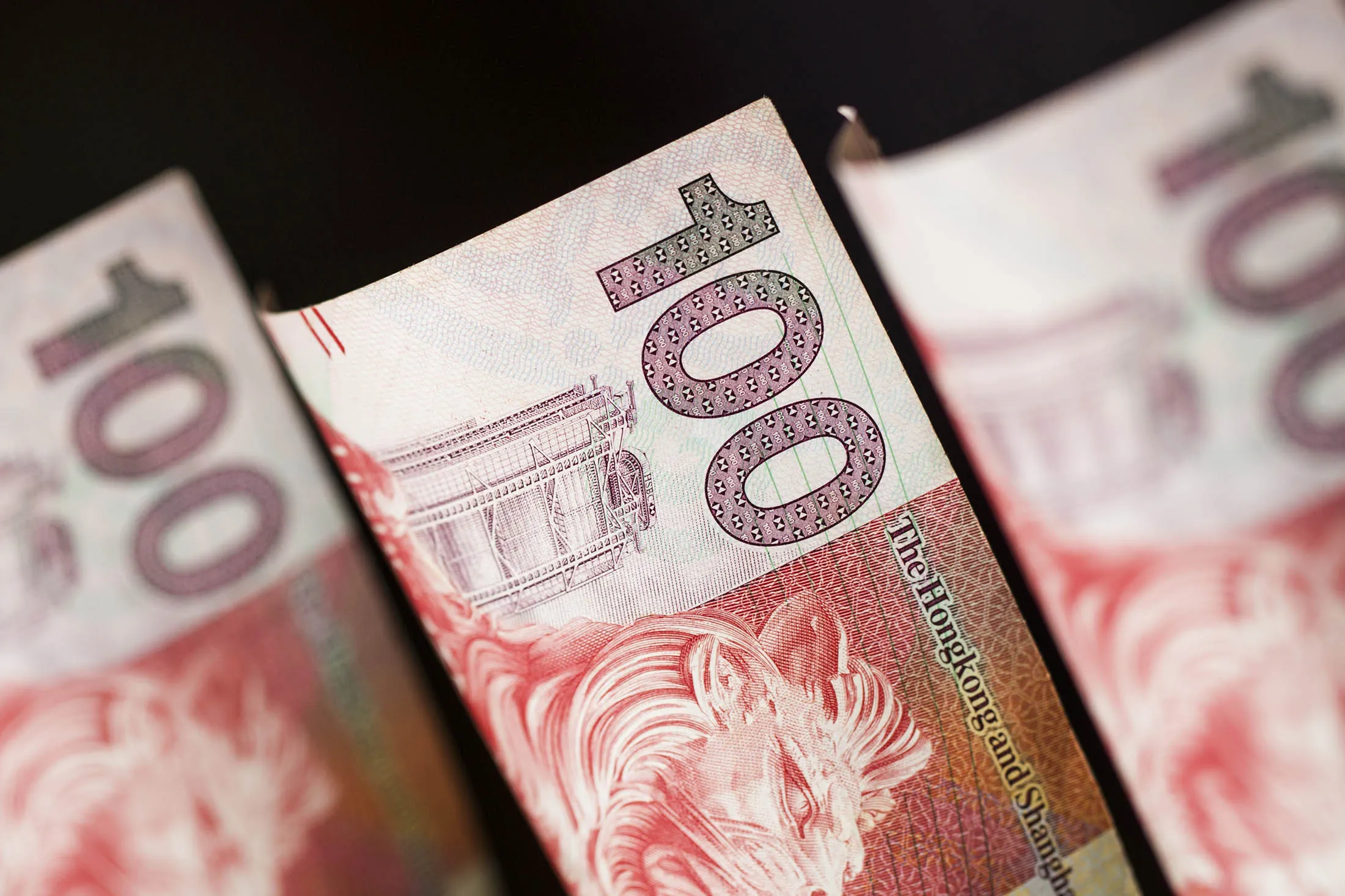 Hong Kong one-hundred dollar banknotes are arranged for a photograph in Hong Kong, China, on Wednesday, Jan. 20, 2016. Hong Kong dollar forwards sank to their weakest level this century, interbank loan rates jumped the most in seven years and the Hang Seng Index tumbled as China's market turmoil fueled speculation the city's 32-year-old currency peg will end.
