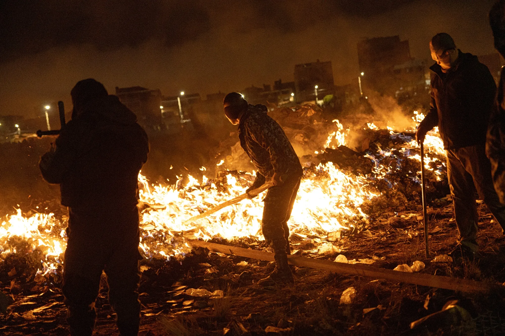 Members of the military burn piles of cash at the scene of a plane crash in El Alto, Bolivia, on Feb. 27.